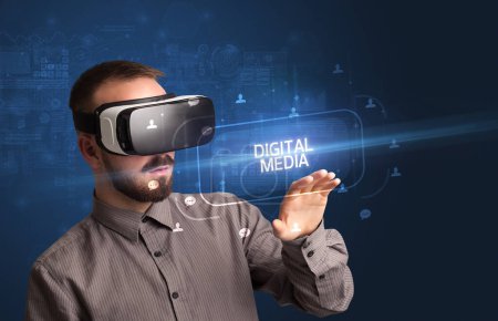 Foto de Hombre de negocios mirando a través de gafas de Realidad Virtual con inscripción DIGITAL MEDIA, concepto de redes sociales - Imagen libre de derechos