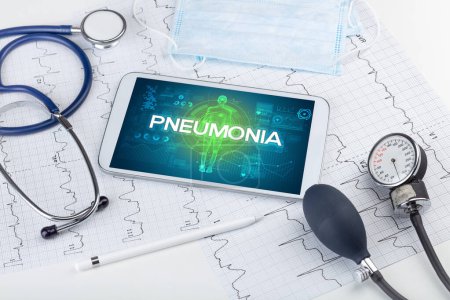 Foto de Tablet PC y herramientas médicas con inscripción PNEUMONIA, concepto coronavirus - Imagen libre de derechos
