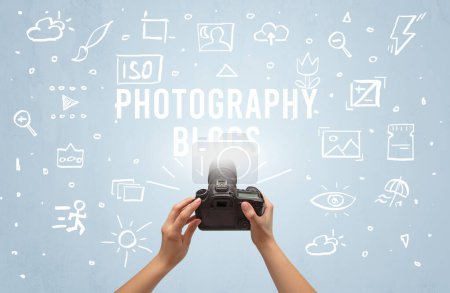 Foto de Fotografía a mano con cámara digital e inscripción FOTOGRAFÍA BLOGS, concepto de ajustes de cámara - Imagen libre de derechos