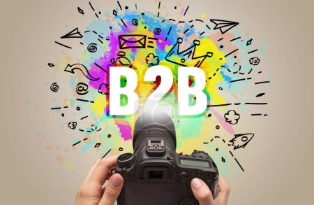 Foto de Primer plano de una cámara digital de mano con dibujo abstracto e inscripción B2B - Imagen libre de derechos