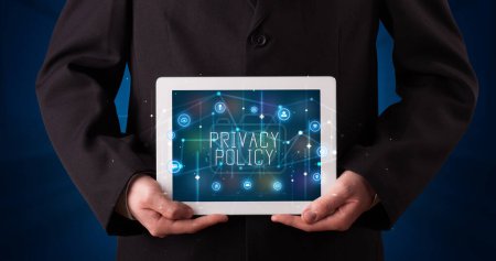 Photo for Young business person working on tablet and shows the digital sign: PRIVACY POLICY - Royalty Free Image