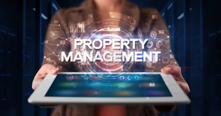 Photo for Young business person working on tablet and shows the inscription: PROPERTY MANAGEMENT, business concept - Royalty Free Image