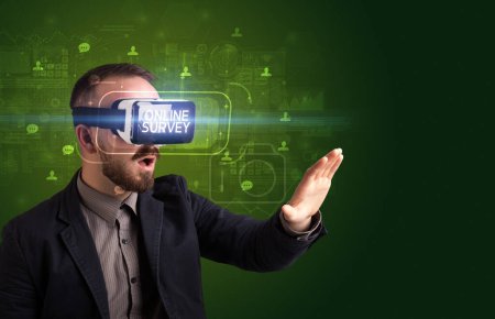 Téléchargez les photos : Homme d'affaires regardant à travers des lunettes de réalité virtuelle avec l'inscription SURVEY EN LIGNE, concept de réseautage social - en image libre de droit