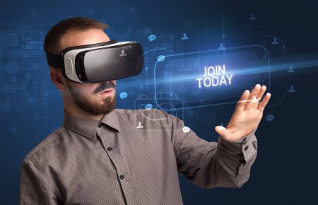 Téléchargez les photos : Homme d'affaires regardant à travers des lunettes de réalité virtuelle avec inscription JOIN TODAY, concept de réseautage social - en image libre de droit