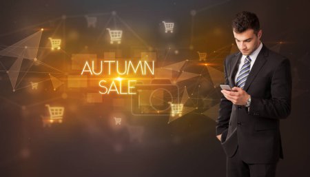 Photo for Businessman with shopping cart icons and AUTUMN SALE inscription, online shopping concept - Royalty Free Image