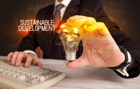 Photo for Businessman holding lightbulb with SUSTAINABLE DEVELOPMENT inscription, Business technology concept - Royalty Free Image