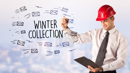 Photo for Handsome businessman with helmet drawing WINTER COLLECTION inscription, contruction sale concept - Royalty Free Image