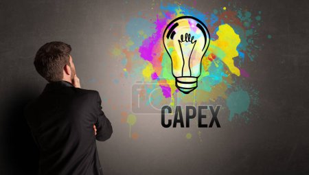 Téléchargez les photos : Homme d'affaires dessin ampoule colorée avec inscription CAPEX sur mur en béton texturé, nouveau concept d'idée d'entreprise - en image libre de droit