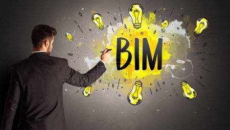 Téléchargez les photos : Homme d'affaires dessin ampoule colorée avec abréviation BIM, concept idée nouvelle technologie - en image libre de droit