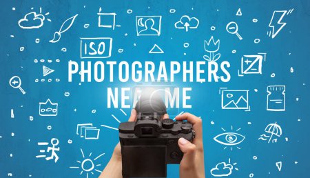 Photo for Hand taking picture with digital camera and PHOTOGRAPHERS NEAR ME inscription, camera settings concept - Royalty Free Image