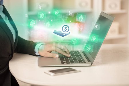 Téléchargez les photos : Homme d'affaires travaillant sur ordinateur portable avec donner des icônes d'argent qui en sortent, concept d'entreprise réussi - en image libre de droit