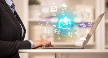 Téléchargez les photos : Homme d'affaires travaillant sur ordinateur portable avec des icônes de courrier qui en sortent, concept d'entreprise en pleine croissance - en image libre de droit