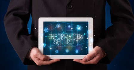 Photo for Young business person working on tablet and shows the digital sign: INFORMATION SECURITY - Royalty Free Image