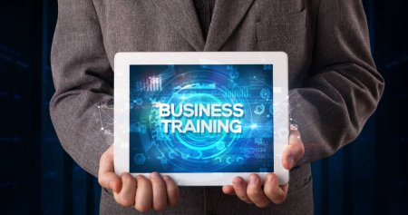 Photo for Young business person working on tablet and shows the inscription: BUSINESS TRAINING, business concept - Royalty Free Image