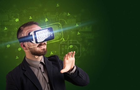 Foto de Hombre de negocios mirando a través de gafas de realidad virtual con inscripción CONCEPTO SOCIAL, concepto de redes sociales - Imagen libre de derechos