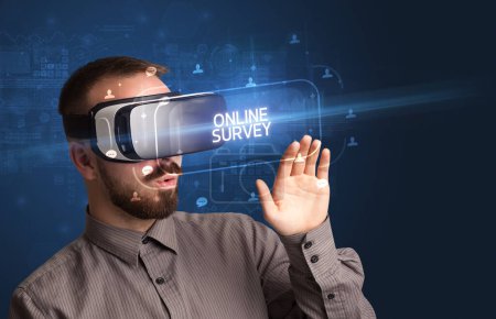 Photo for Businessman looking through Virtual Reality glasses with ONLINE SURVEY inscription, social networking concept - Royalty Free Image