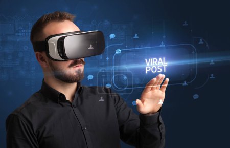 Foto de Hombre de negocios mirando a través de gafas de realidad virtual con inscripción VIRAL POST, concepto de redes sociales - Imagen libre de derechos