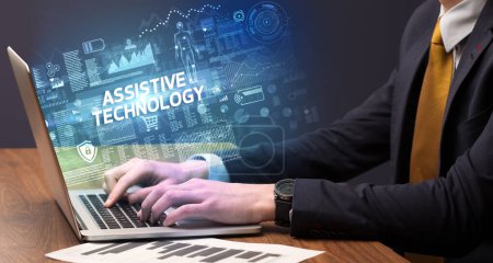 Foto de Empresario trabajando en laptop con inscripción TECNOLOGÍA ASISTENCIA, concepto de cibertecnología - Imagen libre de derechos