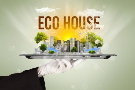 Foto de Camarero sirviendo eco ciudad con inscripción ECO HOUSE, concepto de energía renovable - Imagen libre de derechos