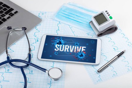 Téléchargez les photos : Tablette pc et outils médicaux sur surface blanche avec inscription SURVIVE, concept pandémique - en image libre de droit