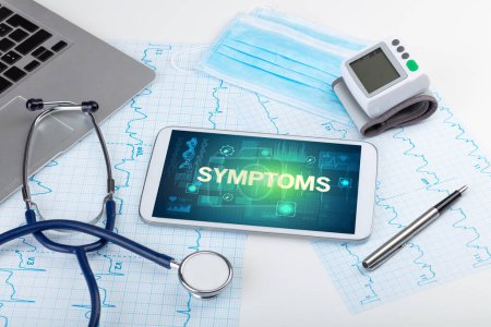 Foto de Tablet PC y material médico con inscripción SYMPTOMS, concepto de prevención - Imagen libre de derechos