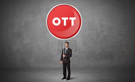 Photo for Young business person holdig traffic sign with OTT abbreviation, technology solution concept - Royalty Free Image