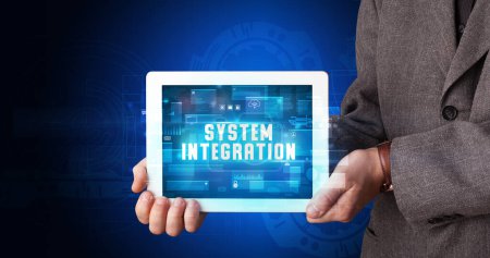 Photo for Young business person working on tablet and shows the digital sign: SYSTEM INTEGRATION - Royalty Free Image