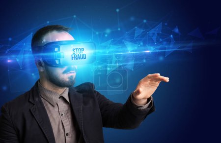 Téléchargez les photos : Homme d'affaires regardant à travers des lunettes de réalité virtuelle avec l'inscription STOP FRAUD, concept de cybersécurité - en image libre de droit