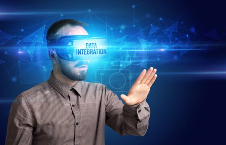 Téléchargez les photos : Homme d'affaires regardant à travers des lunettes de réalité virtuelle avec inscription DATA INTEGRATION, concept de cybersécurité - en image libre de droit