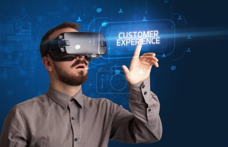 Photo for Businessman looking through Virtual Reality glasses with CUSTOMER EXPERIENCE inscription, social networking concept - Royalty Free Image