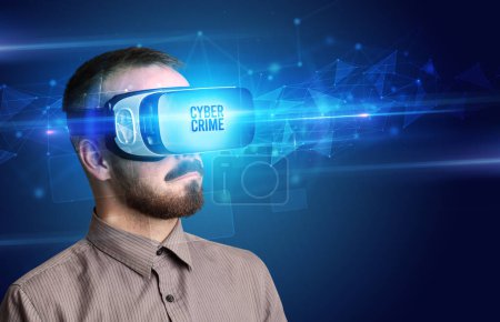 Téléchargez les photos : Homme d'affaires regardant à travers des lunettes de réalité virtuelle avec inscription CYBER CRIME, concept de cybersécurité - en image libre de droit