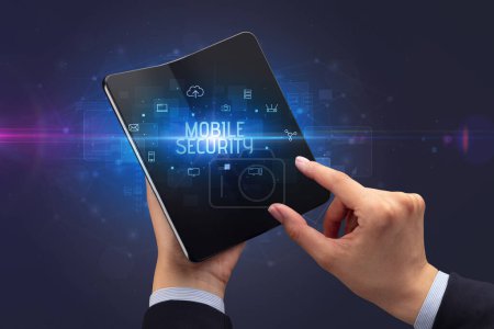Foto de Empresario con un smartphone plegable con inscripción MOBILE SECURITY, concepto de ciberseguridad - Imagen libre de derechos