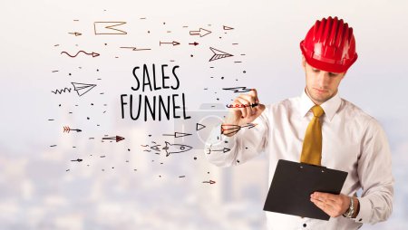 Photo for Handsome businessman with helmet drawing SALES FUNNEL inscription, contruction sale concept - Royalty Free Image