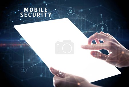 Téléchargez les photos : Tenir tablette futuriste avec inscription MOBILE SECURITY, concept de cybersécurité - en image libre de droit