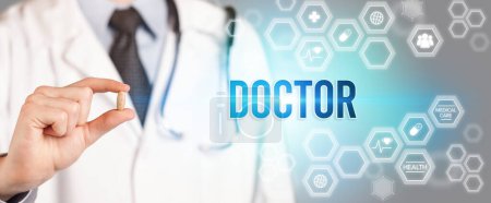 Photo for Close-up of a doctor giving you a pill with DOCTOR inscription, medical concept - Royalty Free Image