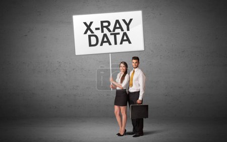 Téléchargez les photos : Homme d'affaires tenant un panneau de signalisation avec inscription X-RAY DATA, nouveau concept d'idée - en image libre de droit