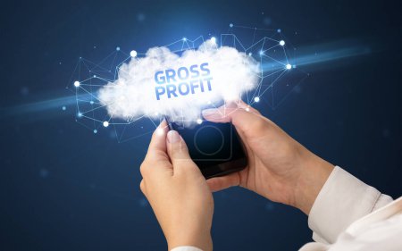 Smartphone de mano femenina con inscripción GROSS PROFIT, concepto de negocio en la nube