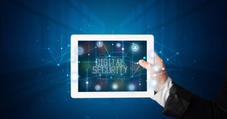 Photo for Young business person working on tablet and shows the digital sign: DIGITAL SECURITY - Royalty Free Image