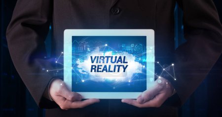 Photo for Young business person working on tablet and shows the inscription: VIRTUAL REALITY - Royalty Free Image