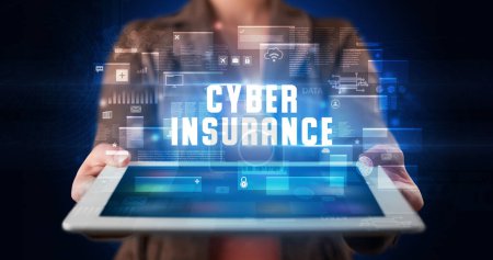 Photo for Young business person working on tablet and shows the digital sign: CYBER INSURANCE - Royalty Free Image