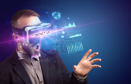 Foto de Hombre de negocios mirando a través de gafas de realidad virtual con inscripción CONTÁCTENOS, nuevo concepto de negocio - Imagen libre de derechos