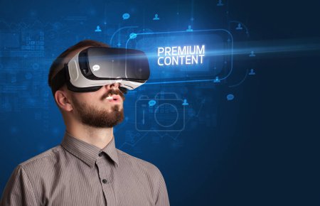 Téléchargez les photos : Homme d'affaires regardant à travers des lunettes de réalité virtuelle avec inscription PREMIUM CONTENT, concept de réseautage social - en image libre de droit