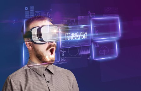 Geschäftsmann blickt durch Virtual-Reality-Brille mit TECHNOLOGY INNOVATION-Aufschrift, neues Technologiekonzept