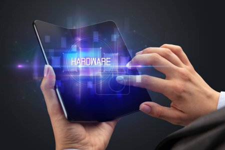 Téléchargez les photos : Homme d'affaires tenant un smartphone pliable avec inscription HARDWARE, nouveau concept technologique - en image libre de droit