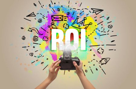 Foto de Primer plano de una cámara digital de mano con dibujo abstracto e inscripción ROI - Imagen libre de derechos