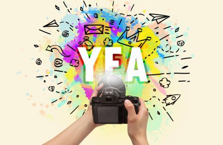 Téléchargez les photos : Gros plan d'un appareil photo numérique à main avec dessin abstrait et inscription YEA - en image libre de droit