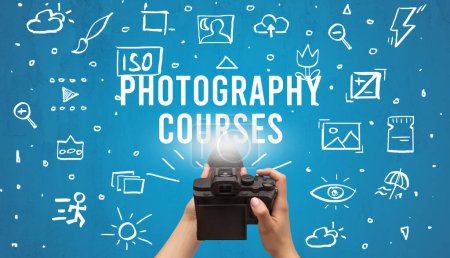 Photo for Hand taking picture with digital camera and PHOTOGRAPHY COURSES inscription, camera settings concept - Royalty Free Image