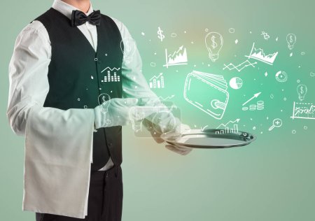 Photo for Handsome young waiter in tuxedo holding tray with wallet icons on tray, global market concept - Royalty Free Image