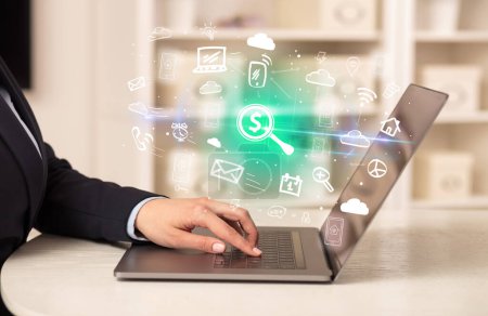 Téléchargez les photos : Homme d'affaires travaillant sur un ordinateur portable avec loupe avec un signe de dollar icônes qui en ressortent, concept d'entreprise en pleine croissance - en image libre de droit