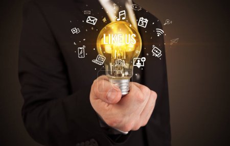 Businessman holding light bulb with LIKE US inscription, social media concept